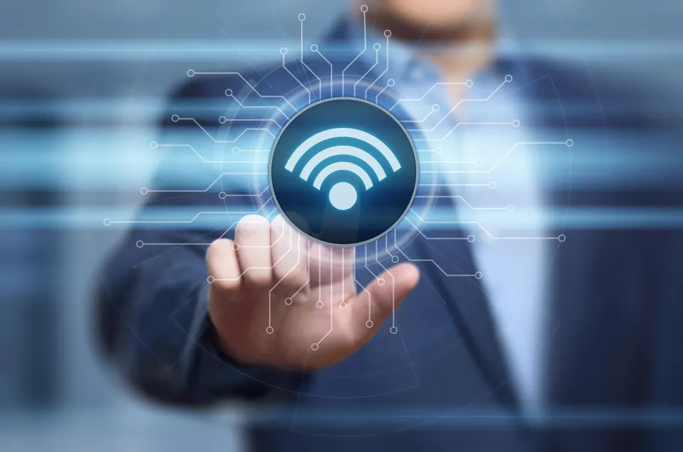 A businessman touches a glowing Wi-Fi symbol on a virtual screen.